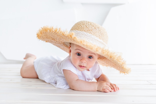 面白いかわいい子の女の子3 4歳の白のトップとデニムのショートパンツを着て麦わら帽子を保持 プレミアム写真