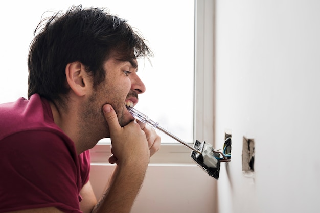 funny-electrician-installing-plug-with-screwdriver-carrying-mouth_23-2148087654.jpg