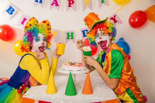 Premium Photo | Funny emotional clowns at the party cannot share the cake