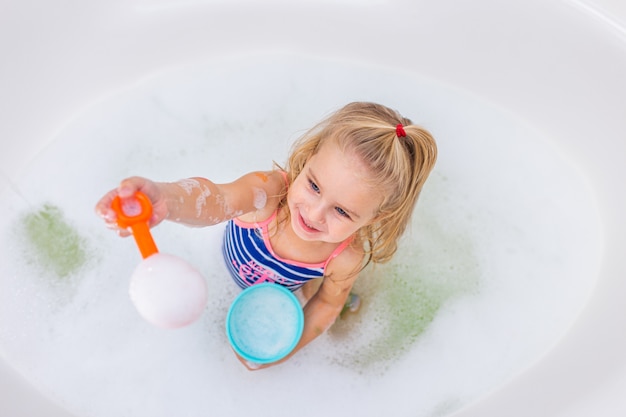 Funny Little Blonde Girl Taking Bubble Bath In Beautiful Bathroom