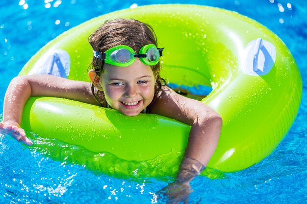 Premium Photo | Funny little girl swims in a pool in an pink life preserver