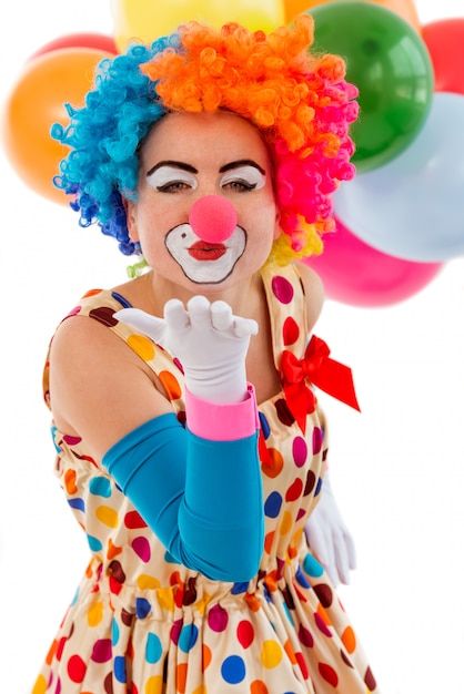 Premium Photo | Funny playful female clown in colorful wig air kissing.