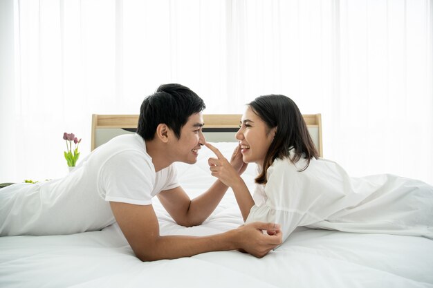 Premium Photo | Funny and romantic asian couple' portrait in bedroom with natural light from window, relationship between husband and wife and being a family.