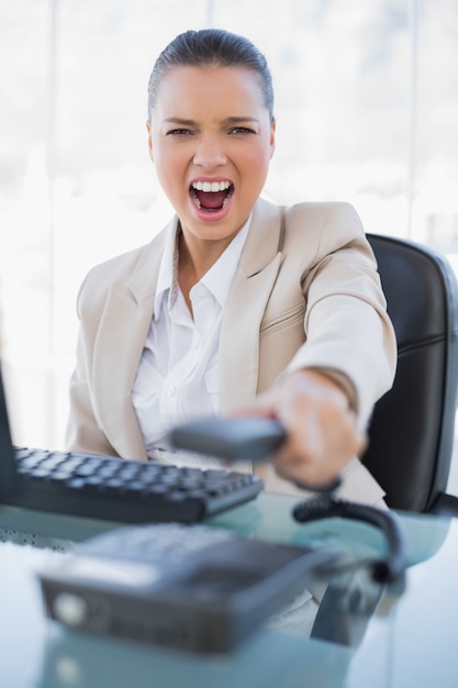 Furious Businesswoman Screaming While Hanging Up The Phone Photo 