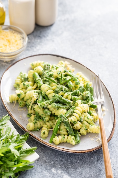 Premium Photo | Fusili pasta with green vegetables and creamy sauce