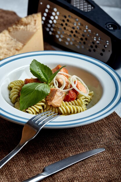 Fusilli pasta with baked salmon and spinach | Premium Photo