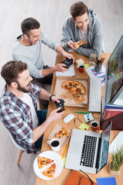 Premium Photo Game Time Top View Of Three Young Men Playing Computer Games And Eating Pizza 2148