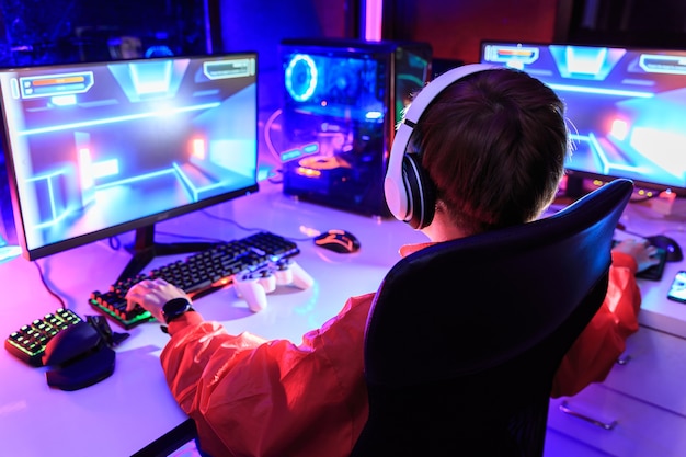 暗い部屋でpc上でオンラインゲームをプレイするゲーマー プレミアム写真