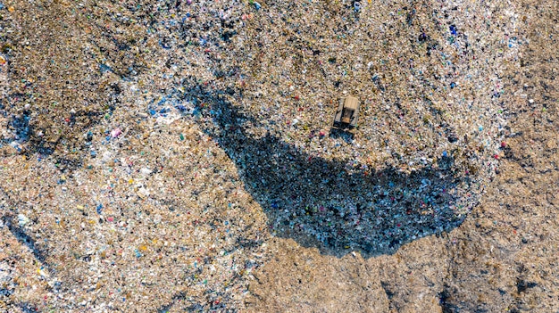 Garbage pile in trash dump or landfill, aerial view garbage trucks unload garbage to a landfill, global warming, ecosystem and healthy environment concepts and background. Premium Photo