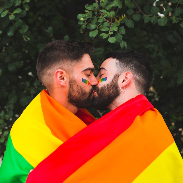 Free Photo Gay Couple Kissing With Rainbow Flag In Park