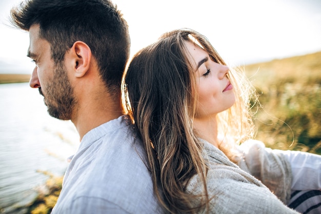 Premium Photo | Gentle and loving couple sitting on the shore at sunset