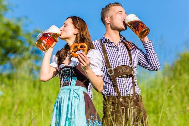 Premium Photo German Couple In Tracht With Beer And Pretzel