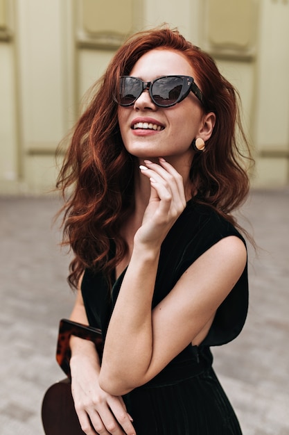 Free Photo Ginger Woman In Trendy Sunglasses Poses Outside And Smiles 