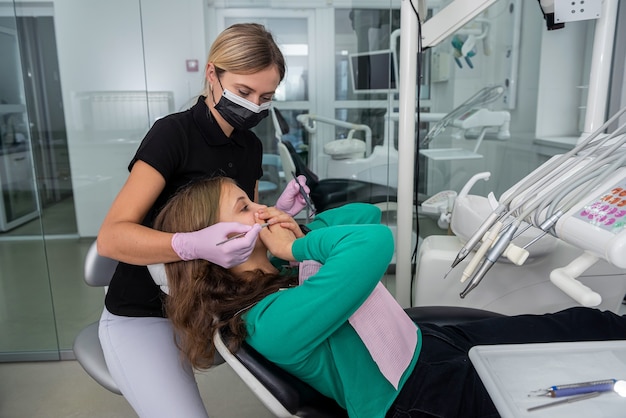 歯科医院の女の子が手で口を閉じて最初の診察を許可しない プレミアム写真