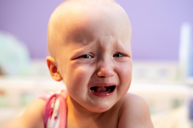 Girl Crying While Standing In Her Crib Premium Photo