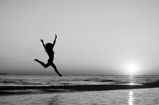 Premium Photo | Girl doing gymnastics on beach at sunset