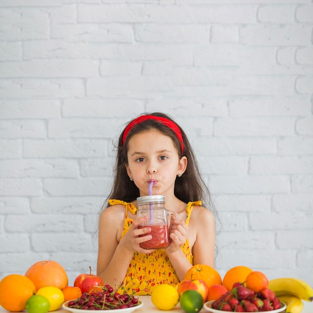 Free Photo Girl Drinking Strawberry Smoothies With Ripe Fruits Over The Desk 
