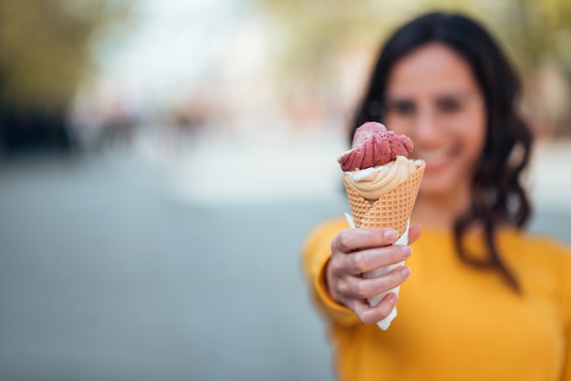 Premium Photo Girl Holding Ice Cream Cone Toward Camera Outdoors Focus On The Foreground Copy Space