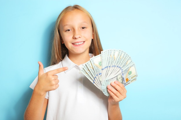 Premium Photo | Girl holding money in hands on a blue background close up