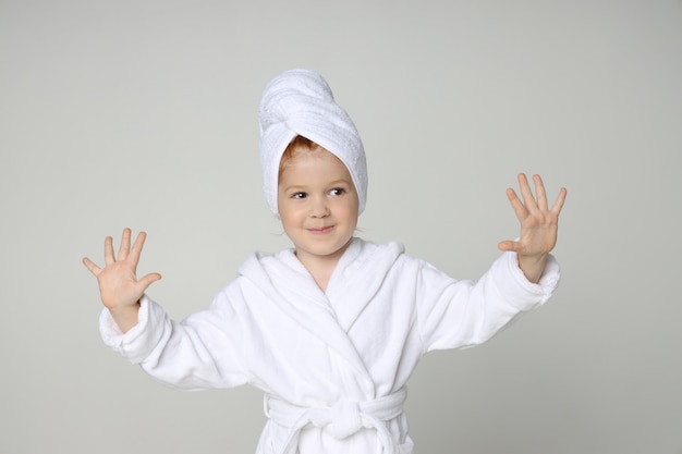 シャワーを浴びて髪を洗った後 白いローブとタオルを頭に抱えた少女 プレミアム写真