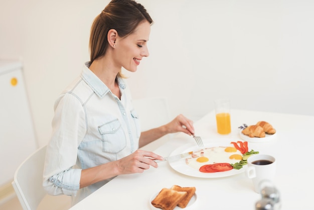 The girl is having breakfast in the kitchen Premium Photo