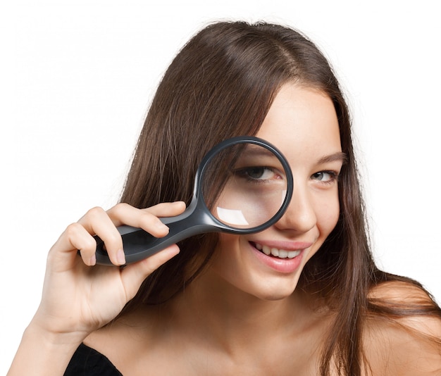 Girl looking through a magnifying glass Premium Photo