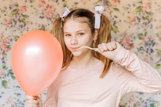 Girl Popping Balloon With Fork Looking At Camera Free Photo