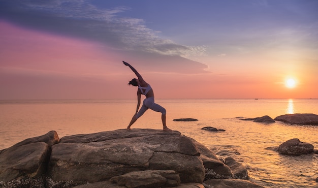 Premium Photo | Girl practicing yoga on a rock