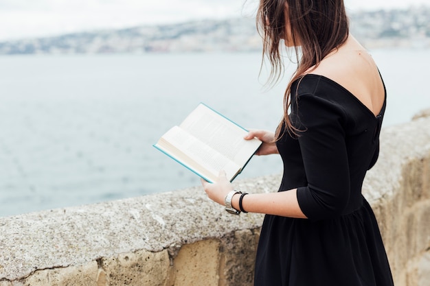 Free Photo | Girl reading a book near the sea