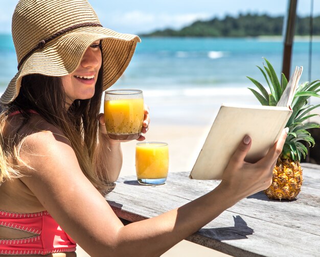 Premium Photo A Girl Reads A Book By The Sea