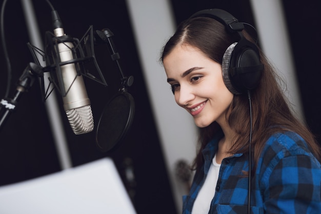 Premium Photo | The girl in the recording studio sings a song.