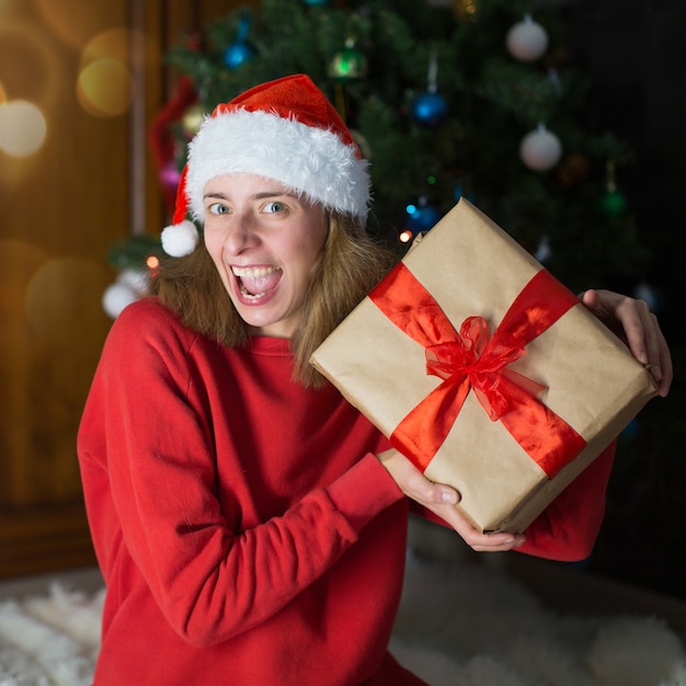 Premium Photo | Girl in red clothes unfold new year gifts. the concept ...