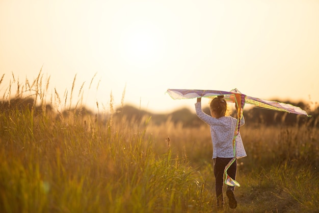 Premium Photo | A girl runs into a field with a kite, learns to launch ...