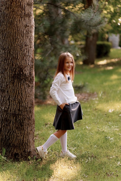 Premium Photo | A girl in a school uniform walks in the park