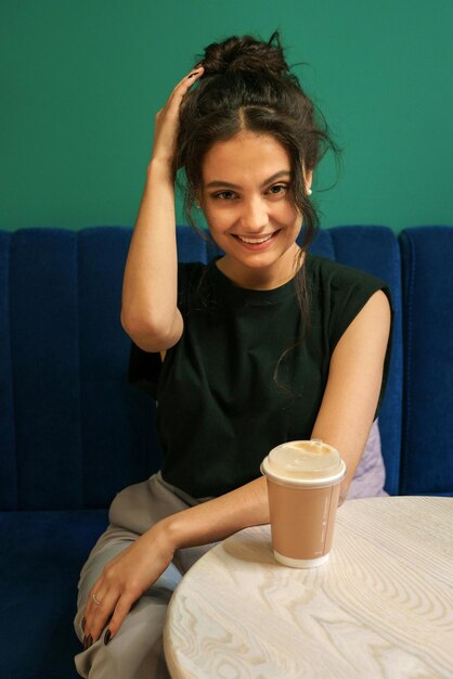 Premium Photo A Girl Sits At A Table In A Cafe With A Glass Of Coffee