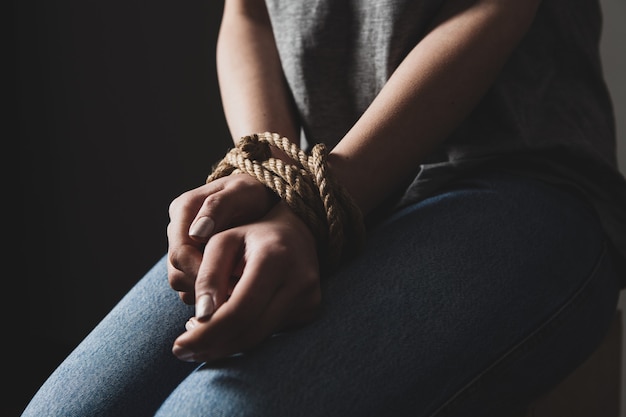 Premium Photo | A girl sits tied on a chair in a dark room