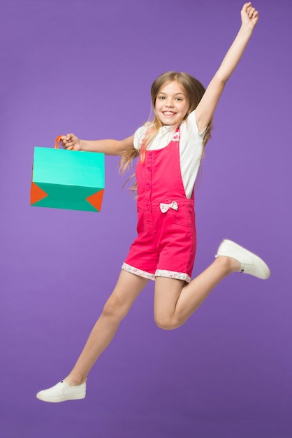Premium Photo Girl On Smiling Face Carries Shopping Bag And Jumps
