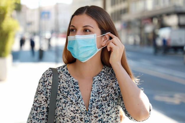 Premium Photo | Girl in the street puts on a medical mask. young ...