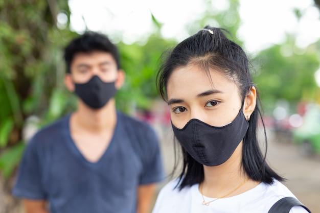 The girl on the street wearing a face mask to prevent the virus and resist haze. Free Photo