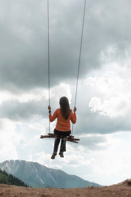 Premium Photo The Girl Swings On A Swing Over The Mountains A Feeling Of Flight And Freedom