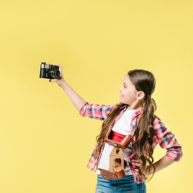 Free Photo | Girl taking selfie with camera in studio