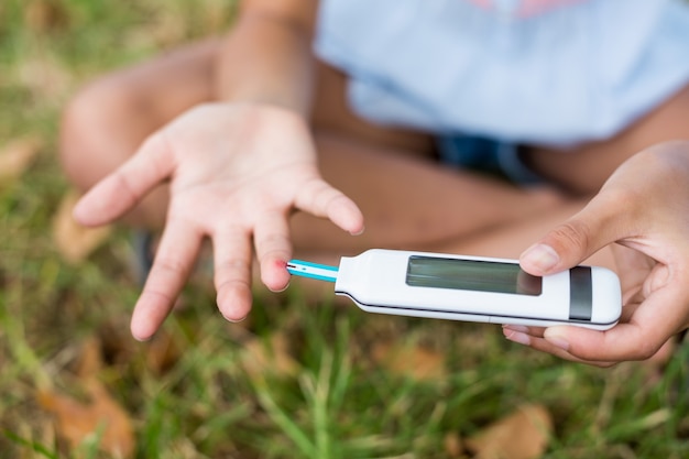 Girl testing diabetes on glucose meter Premium Photo