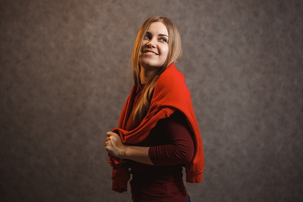 Premium Photo Girl Tries On A Red Sweater On A Gray Background