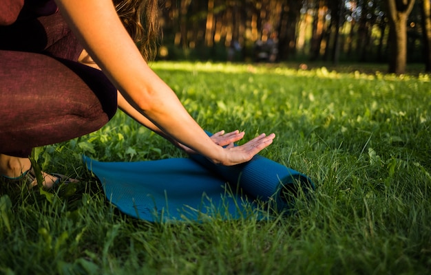 Premium Photo The Girl Unfurls A Yoga Mat On Nature