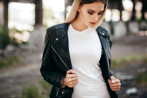 Premium Photo | Girl wearing t-shirt and leather jacket posing against ...