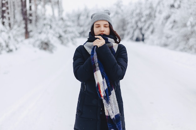 Premium Photo | A girl wearing a winter hat poses on a camera in the ...