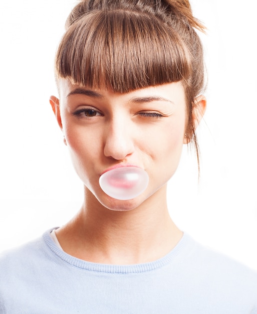 Girl winking and making a bubble with a gum Photo | Free Download