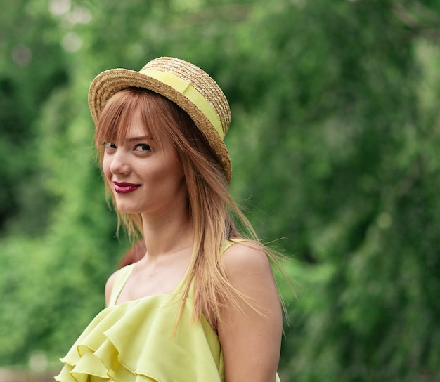 Girl with long hair in a dress and hat walks Premium Photo