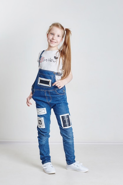 Premium Photo | Girl with pigtails in a denim overalls on white.