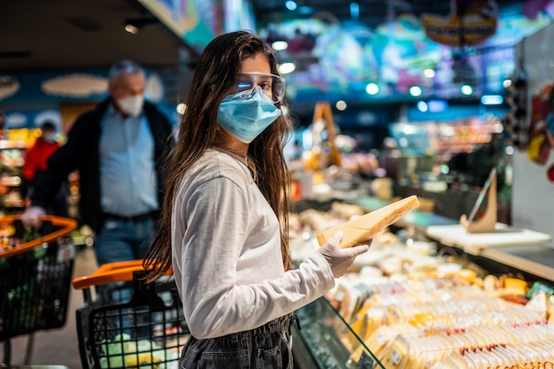 The girl with surgical mask is going to buy cheese. Free Photo
